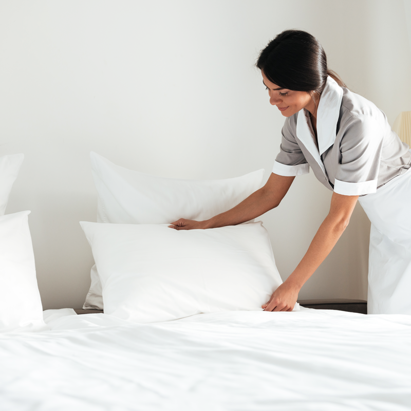 young-hotel-maid-setting-up-pillow-bed